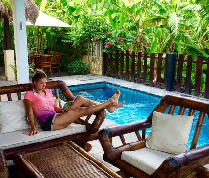 Surf WG Surfcamp Bali eine Frau relaxt am Haupthaus Pool