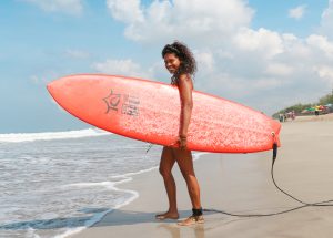 SurfWG Bali girl with orange surf board at kuta beach