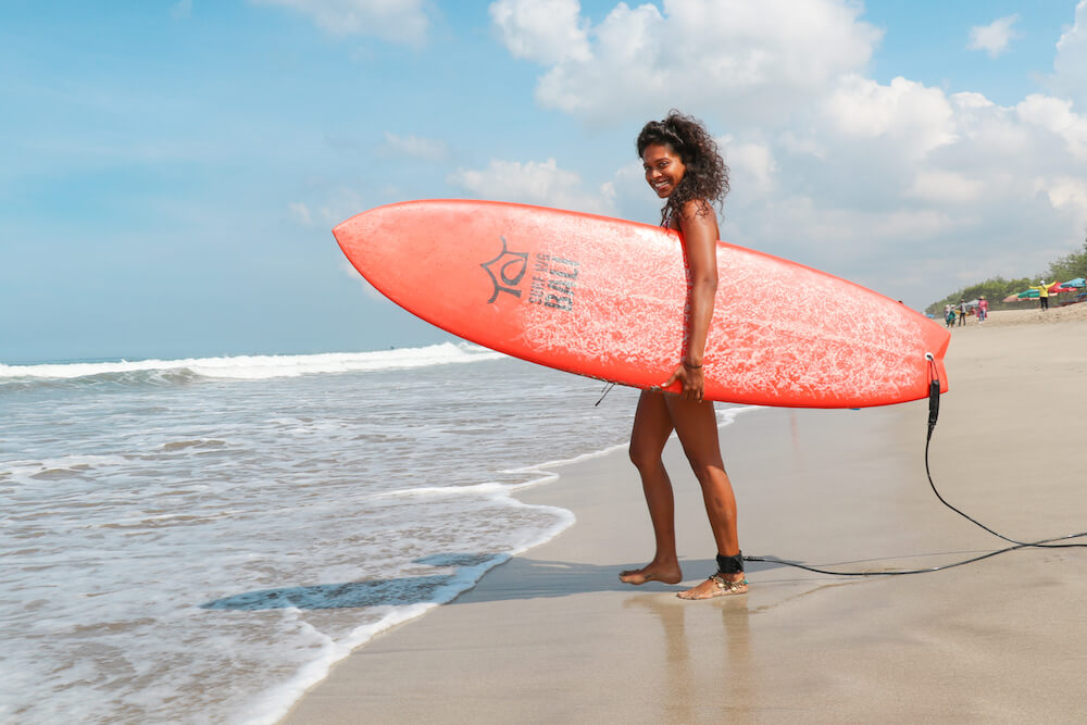 SurfWG Bali girl with orange surf board at kuta beach