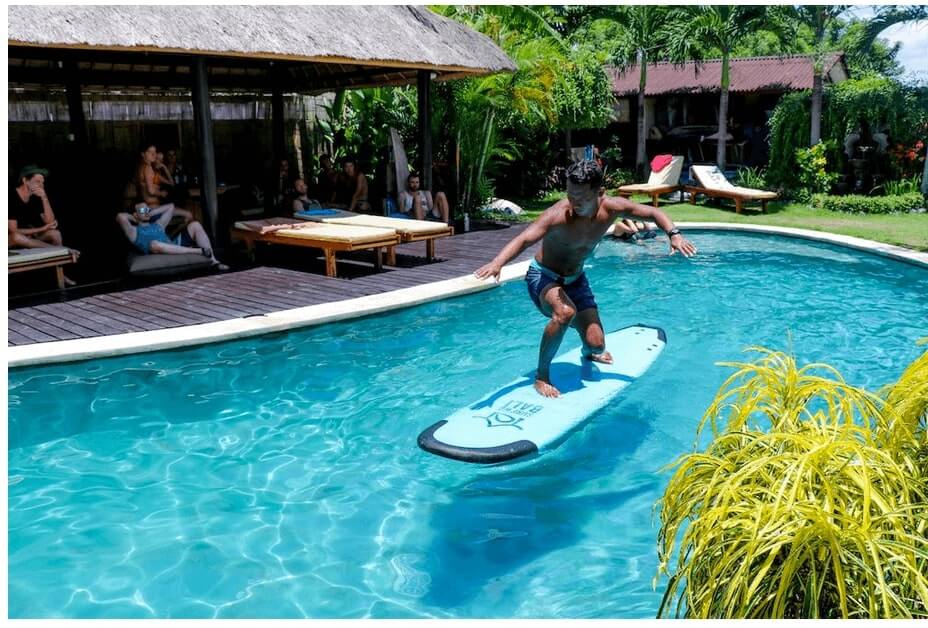 Surf school at surfWG bali surf camp pool training surfguide Eddi2 on surfboard floating in Pool